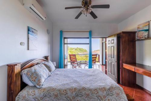 Ocotal Beach Front Condo #38 في Ocotal: غرفة نوم مع سرير مع مروحة سقف وشرفة