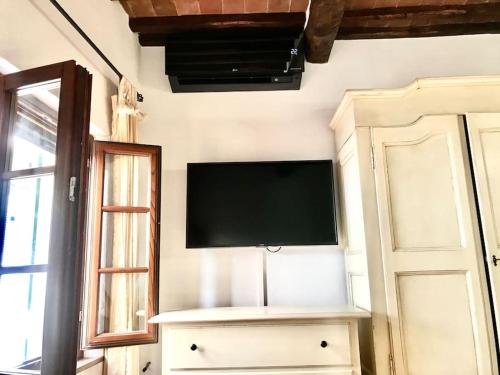 a flat screen tv on a wall next to a door at Vicolo Curtatone 30 in Foiano della Chiana