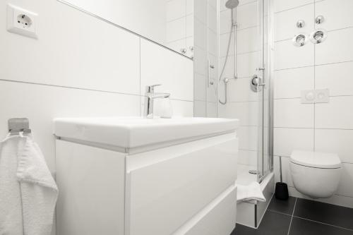 a white bathroom with a sink and a toilet at Löwe Apartments "Gelb" Tiengen Altstadt in Waldshut-Tiengen