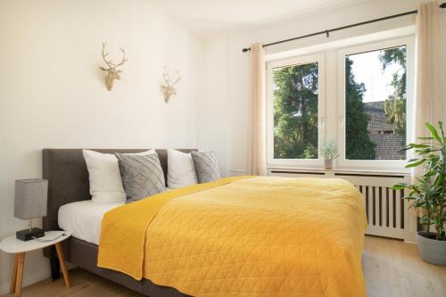 a bedroom with a bed with a yellow blanket at Löwe Apartment Gelb Tiengen Altstadt in Waldshut-Tiengen