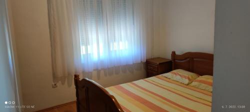 Habitación pequeña con cama y ventana en Apartman Bojovic Sutomore en Sutomore
