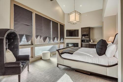 a bedroom with a bed and a chair and windows at Resort Room Hotel Room in Park City