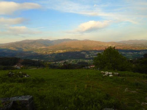 a view of a green field with mountains in the background at Charming House in Andeviso with Mountain View in Arcos de Valdevez