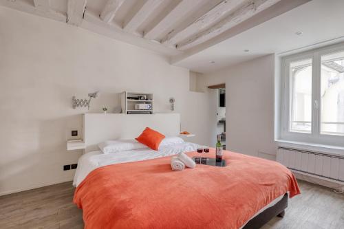 巴黎的住宿－Large and Modern 1Brd Flat at Lovely Saint Germain，白色卧室配有一张带橙色毯子的大床