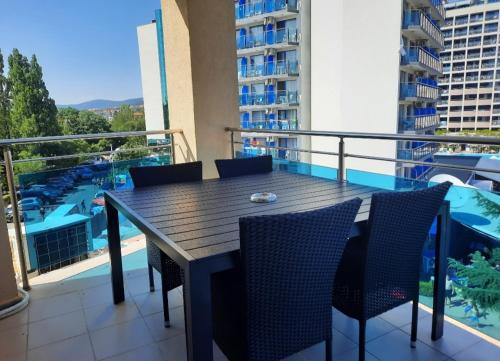 einen Tisch und Stühle auf einem Balkon mit Poolblick in der Unterkunft Apartment "Palace" in Sonnenstrand
