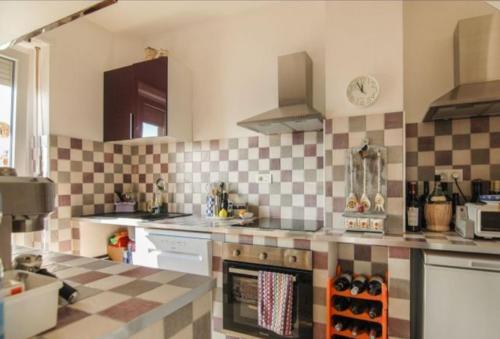 a kitchen with checkered tiles on the wall at TORRE PELLICE Alloggio incantevole con parcheggio privato in Torre Pellice