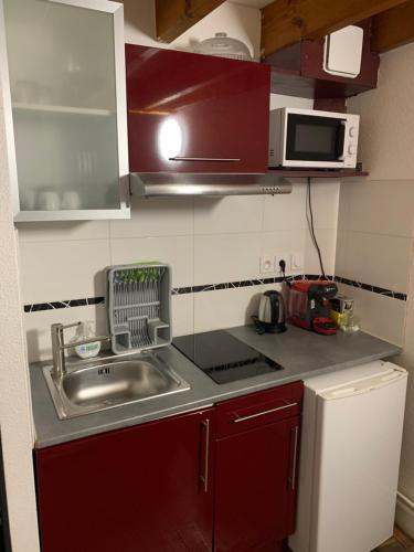a small kitchen with a sink and a microwave at Appartements Victor et Hugo in Bordeaux