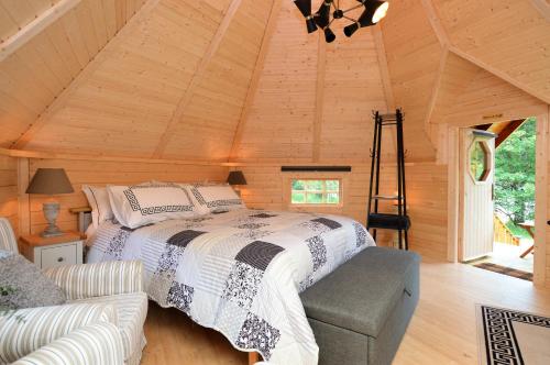 um quarto com uma cama num chalé de madeira em Seal Point Cabin - Luxury Glamping em Cairndow