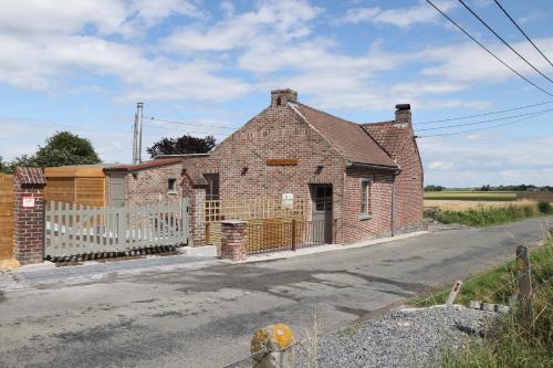 an old brick house on the side of a road at La Petite Mazure in Maulde