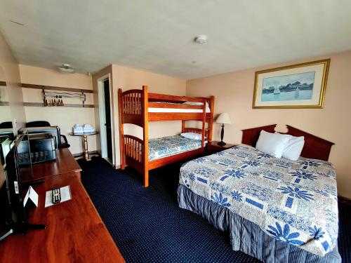 a hotel room with a bed and a bunk bed at Regal Inn Hampton Beach in Hampton