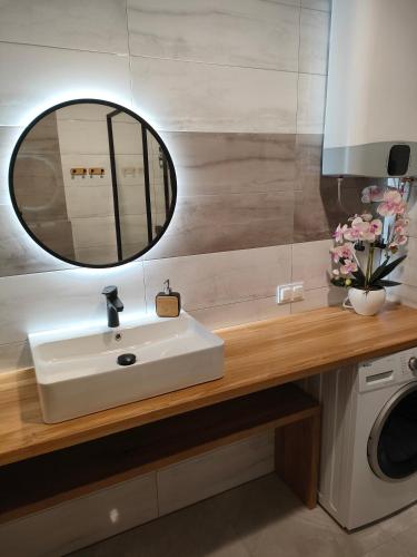 a bathroom with a sink and a mirror at Apartament z widokiem in Mrągowo
