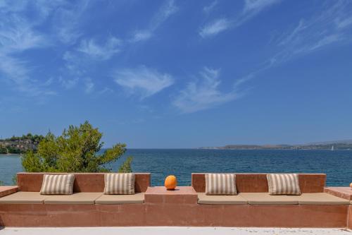 a bench with pillows and an orange ball on it next to the water at Via Lassi Kefalonia in Argostoli