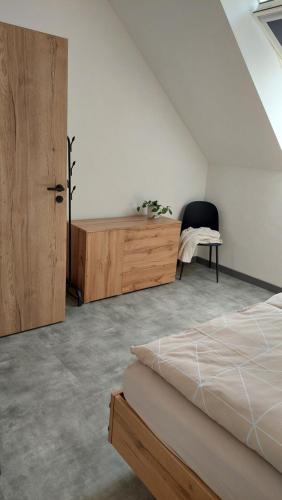 Schlafzimmer mit einem Bett und einem Holzschrank in der Unterkunft Apartmán Po schodech nahoru in Bořetice