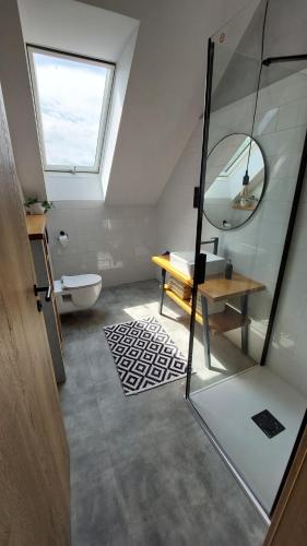 ein Bad mit einem Fenster, einem Waschbecken und einem Spiegel in der Unterkunft Apartmán Po schodech nahoru in Bořetice