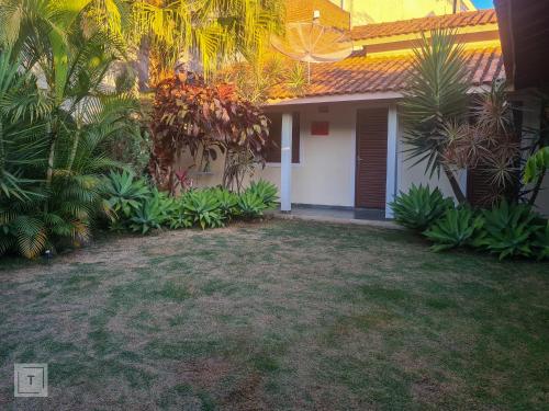 a small house with a white door and some palm trees at Hospedaria do Ernesto in Itanhandu