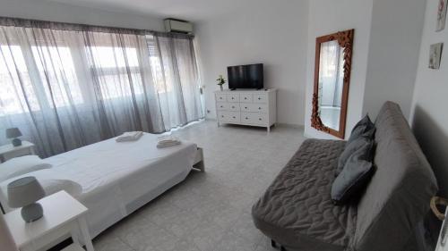 ein Schlafzimmer mit einem Bett, einem Sofa und einem Spiegel in der Unterkunft Gio apartment Marconi in Rom