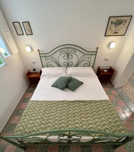 a bedroom with a large bed with a green frame at Casa Margherita - Guest House in Pezze di Greco