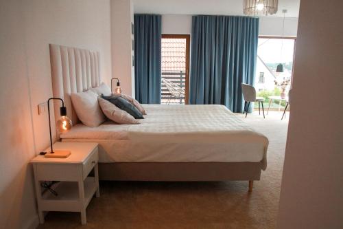 sypialnia z łóżkiem, stołem i oknem w obiekcie Apartament Ósemka w mieście Mikołajki