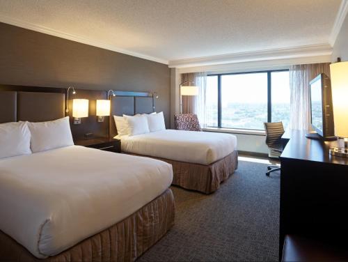 a hotel room with two beds and a window at Sonesta San Jose - Milpitas in Milpitas