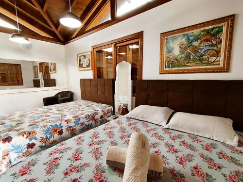 a bedroom with a bed and a painting on the wall at Pousada Estrela Do Luar in Urubici