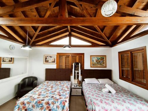 1 dormitorio con 1 cama en una habitación con techos de madera en Pousada Estrela Do Luar, en Urubici