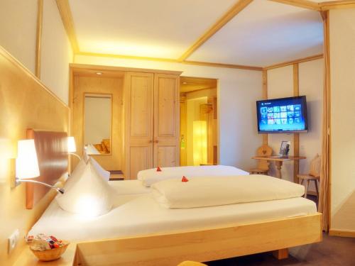 a hotel room with two beds and a television at Hotel Grüner Baum in Würzburg