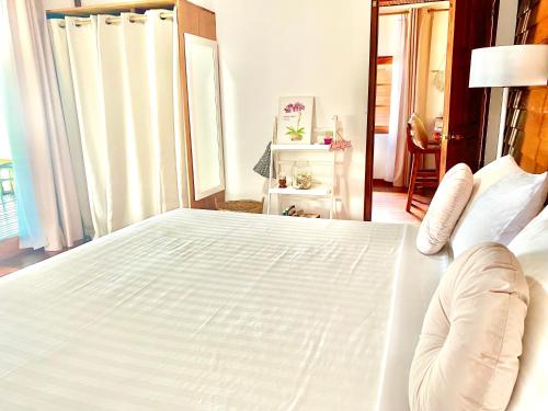 a large white bed in a room with a window at Hin Kong Sunset Beach Front House in Srithanu