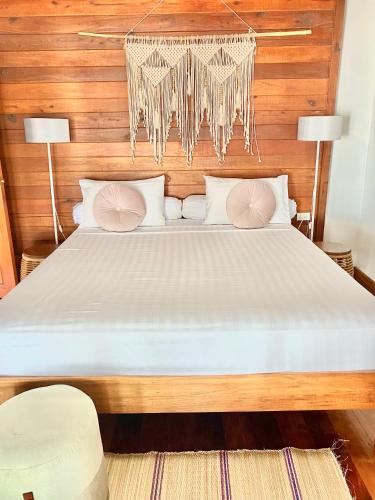 a bedroom with a large bed with a chandelier at Hin Kong Sunset Beach Front House in Srithanu