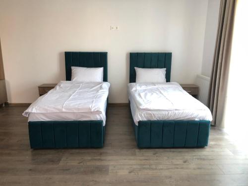 two beds sitting next to each other in a room at Aparthotel Plevnei1 in Cluj-Napoca