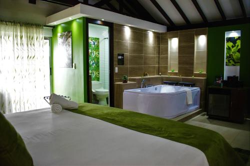 uma casa de banho com uma grande banheira e um grande lavatório. em Hotel Jade Spa em Santa Rosa de Cabal