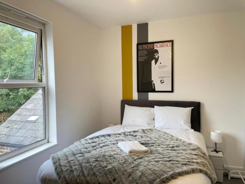 a bedroom with a bed with a poster on the wall at St Peter's Shared House in Birmingham