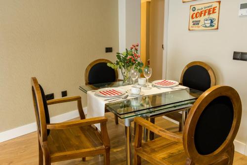 a dining room table with chairs and a table cloth at AB Apartamentos Museum in Málaga
