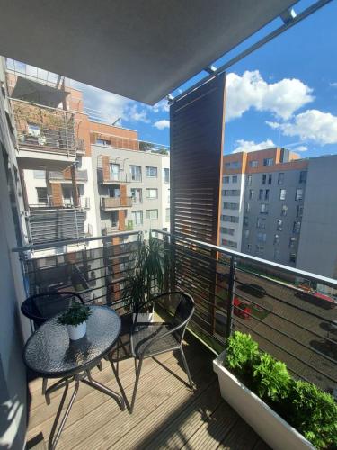 - un balcon avec une table et des chaises dans l'établissement Modern Apartment - Francuska Park, à Katowice