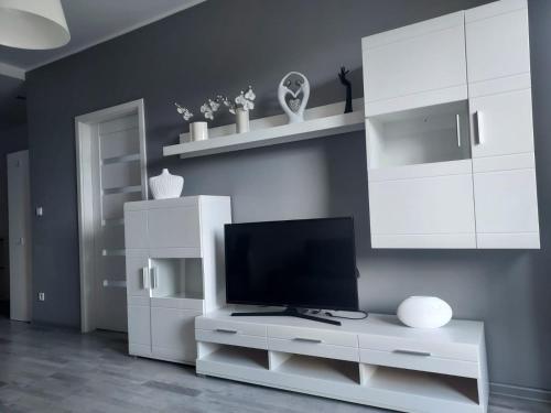 una sala de estar con TV en un armario blanco en Modern Apartment - Francuska Park en Katowice