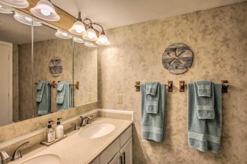 a bathroom with a sink and a mirror and towels at North Myrtle Beach Oceanfront Condo with Pool! in Myrtle Beach