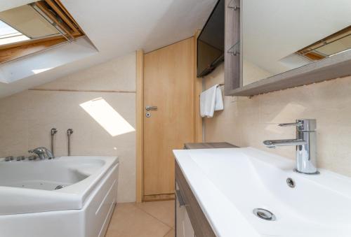 La salle de bains est pourvue d'un lavabo blanc et d'une douche. dans l'établissement Villa Anabella, à Supetar