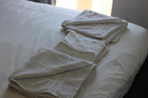 a pile of towels sitting on top of a bed at City Centre Luxury Apartments in Belfast