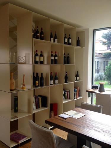 a room with a table and shelves of wine bottles at Casa Sull'Albero in Malgrate