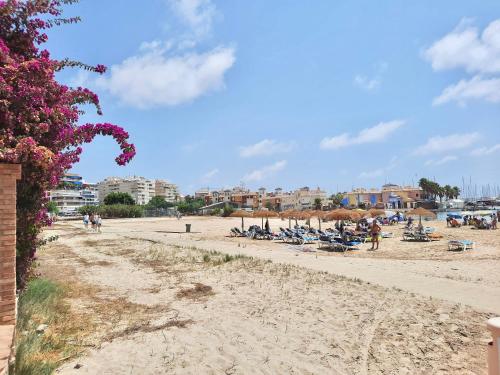 Plaża z grupą ludzi siedzących na piasku w obiekcie Sinforosa Park Apartments w mieście Torrevieja