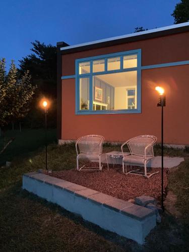 two chairs sitting in front of a house at night at Eden's Echoes Country Retreat in Blacksburg