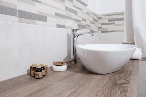 een badkamer met een wit bad en een wastafel bij Claudio Rooms in Fabbrico
