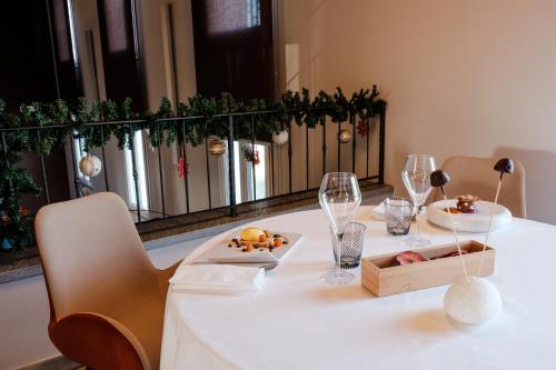 a white table with wine glasses and food on it at Claudio Rooms in Fabbrico