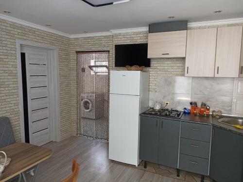 a kitchen with a white refrigerator and a table at Частный дом Ленкорань in Lankaran