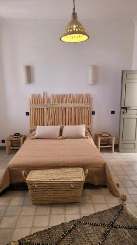 a bedroom with a large bed and a light at Riad Nohad Marrakech Villa Privatisée in Oulad Boudene