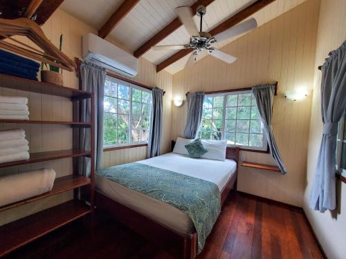 a small bedroom with a bed and a window at Placencia Villas in Placencia