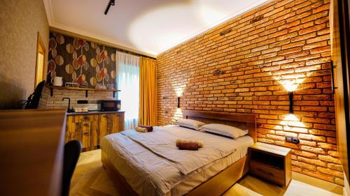 um quarto com uma parede de tijolos e uma cama em Anbani Apartments - City Center em Tbilisi