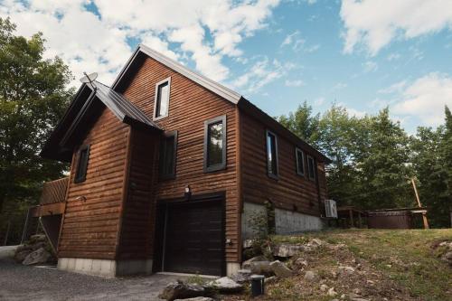 a wooden house with a garage at Chalet Bonheur -Rustique- Pet friendly in Rivière-Rouge