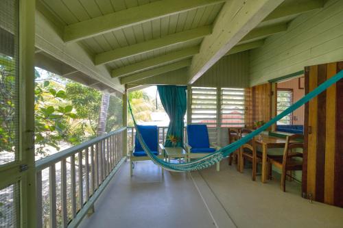 a hammock on the balcony of a house at Placencia Villas in Placencia Village