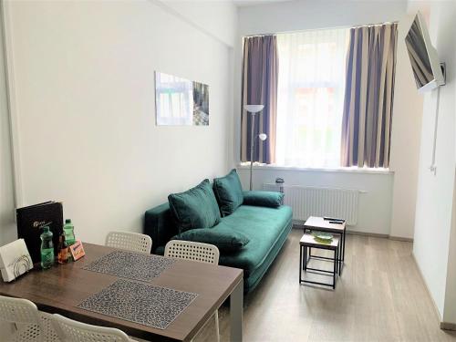 een woonkamer met een groene bank en een tafel bij Apartment Philip Vienna Self Check-In in Wenen