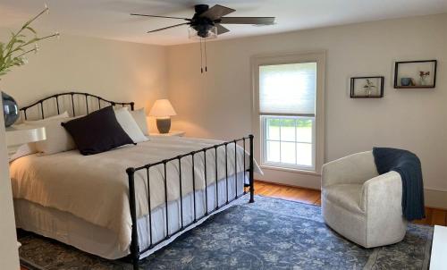 a bedroom with a bed and a chair and a window at Graves Mountain Farm & Lodges in Syria